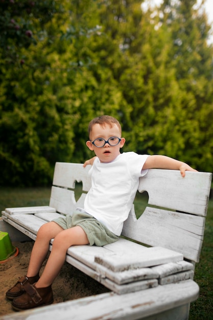 Free photo full shot kid sitting on bench