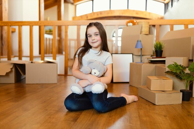 Full shot kid sitting on floor with toy