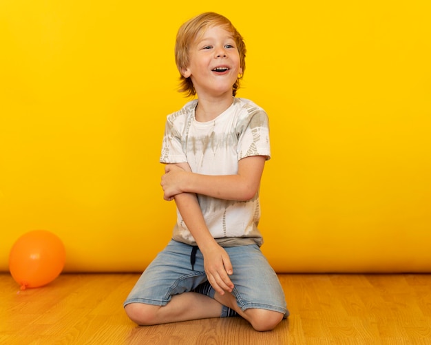 Foto gratuita ragazzo pieno di colpi seduto sul pavimento