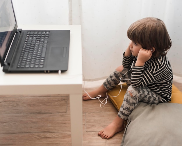 Free photo full shot kid using headphones