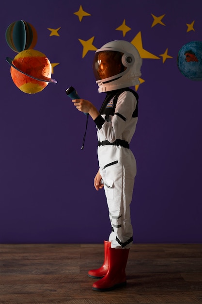 Full shot kid wearing spacesuit