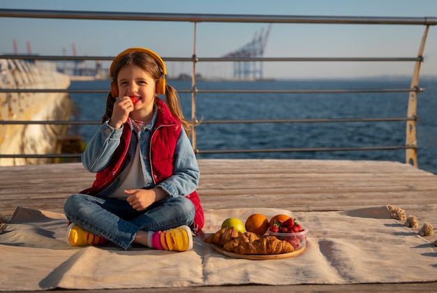 Foto gratuita ragazzino pieno di cibo su un molo