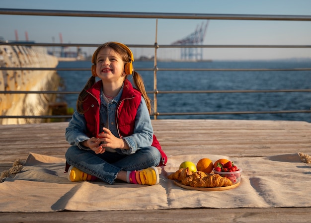 Foto gratuita ragazzino pieno di cibo su un molo