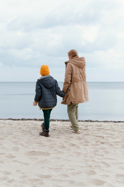 手をつないでフルショットの子供と女性