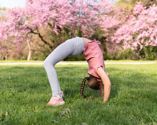 草の上で運動するフルショットの子供