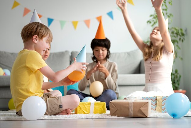 風船で誕生日を祝うフルショットの子供たち