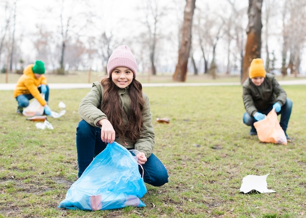 Foto gratuita colpo pieno di bambini che puliscono il terreno