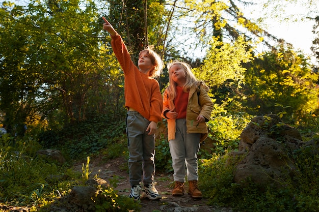 Foto gratuita bambini a figura intera che esplorano la natura insieme