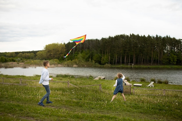 屋外で凧を飛ばすフルショットの子供たち