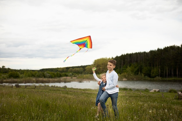 Full shot kids flying a kite together