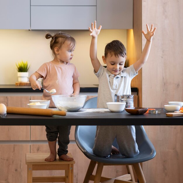 キッチンで楽しんでいるフルショットの子供たち