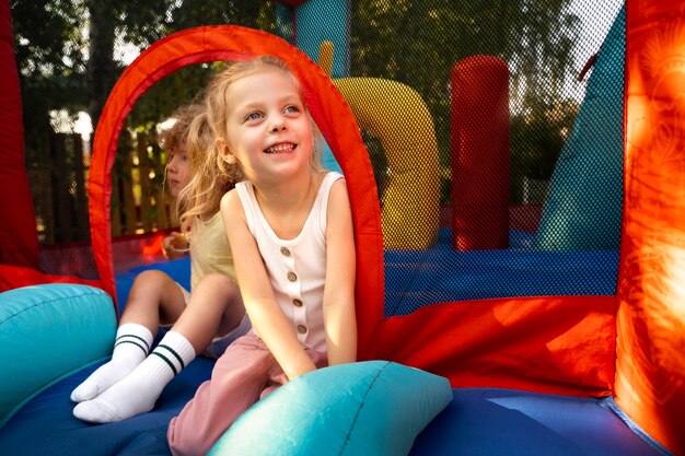 Full shot kids laying in bounce house