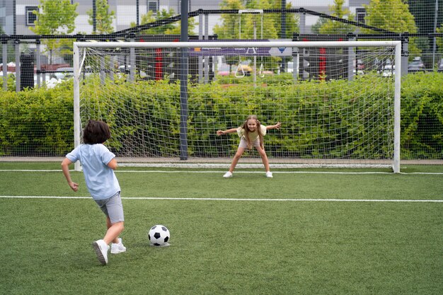 サッカーをするフルショットの子供たち