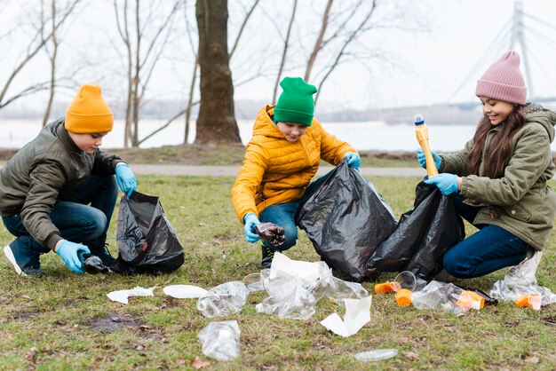 Full shot of kids recycling on ground