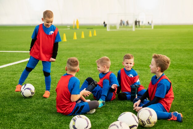 Full shot kids sitting on field