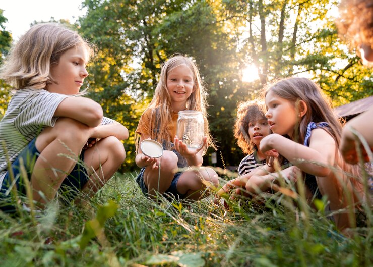 Free Photo full shot kids sitting on grass