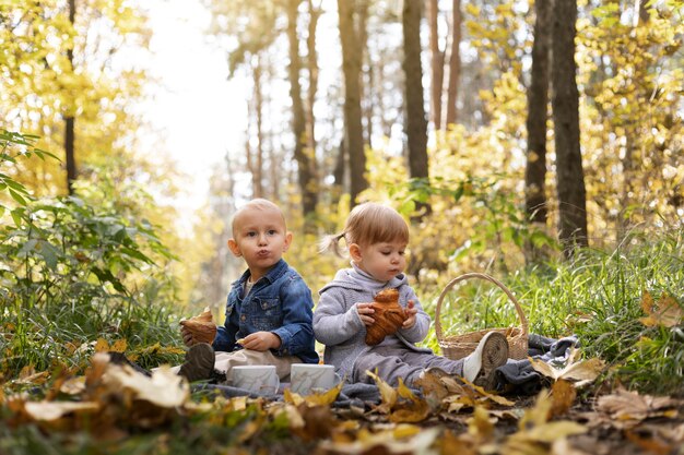 Полный снимок детей, сидящих на листьях