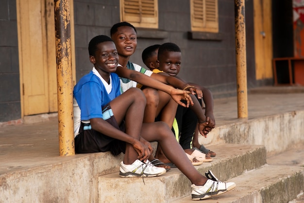 Free photo full shot kids sitting on stairs