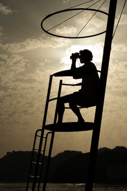 Free photo full shot lifeguard with binoculars