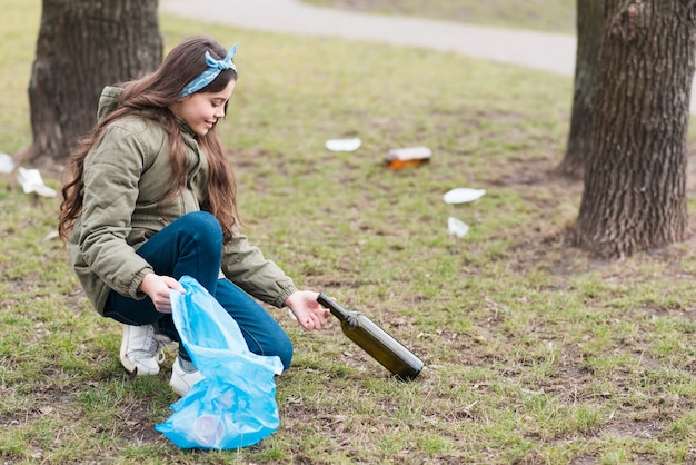 Full shot of little girl cleaning the ground