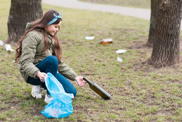 Full shot of little girl cleaning the ground