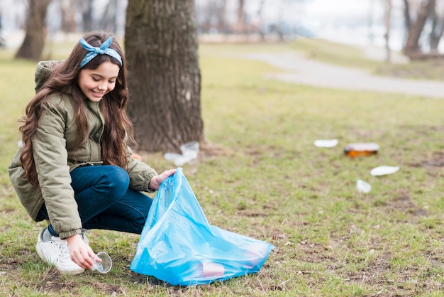 Free photo full shot of little girl recycling