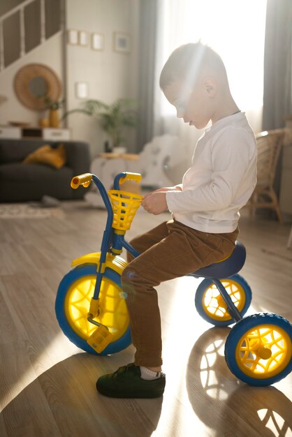 Full shot little kid sitting on tricycle