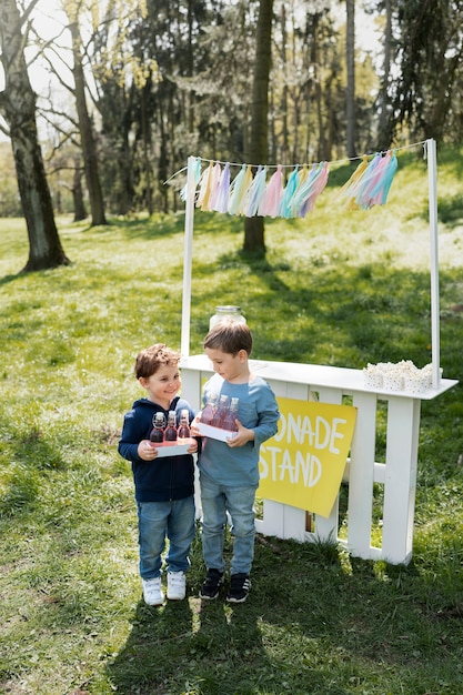 Full shot little kids with lemonade