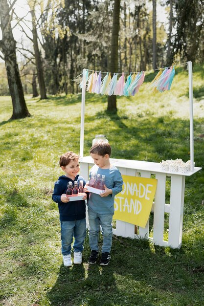 Full shot little kids with lemonade