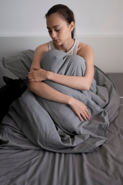 Free photo full shot lonely woman with blanket