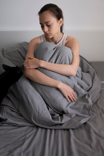 Full shot lonely woman with blanket