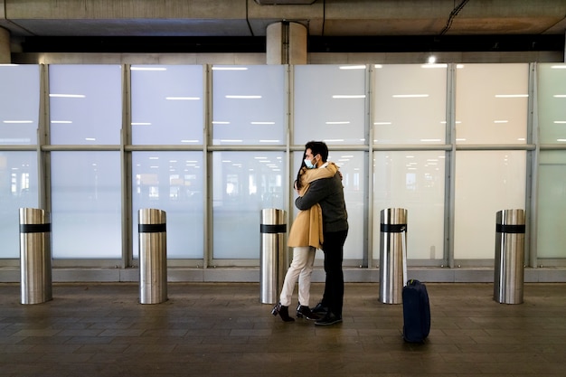 Бесплатное фото Полноценная встреча пары на расстоянии в аэропорту