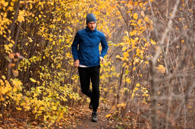 Full shot male running on trail in forest