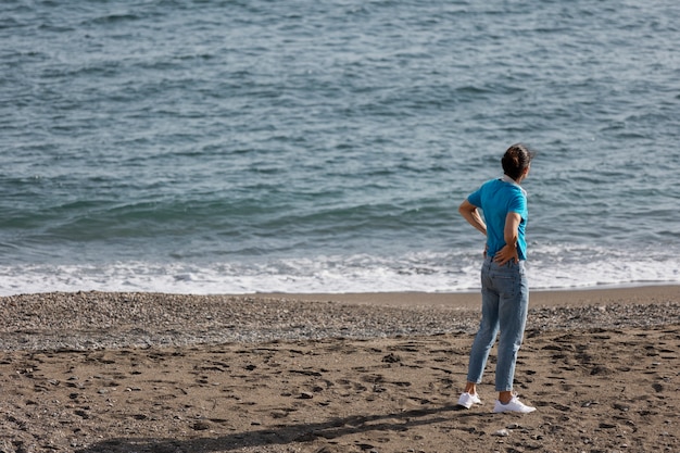 Foto gratuita uomo a figura intera da solo in spiaggia