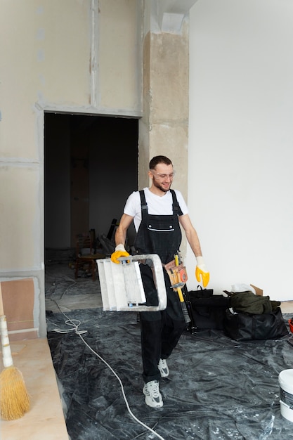 Free photo full shot man carrying ladder