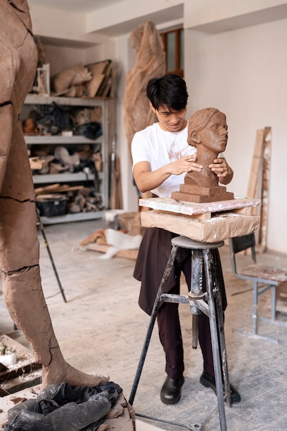 Full shot man clay sculpting