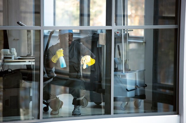 full shot man cleaning window