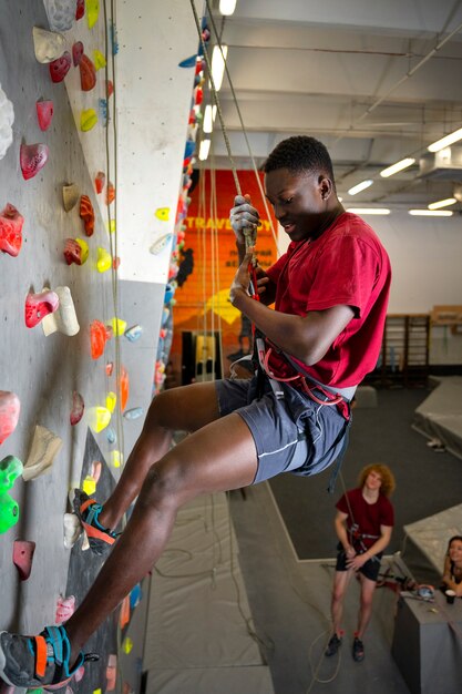 Full shot man climbing wall