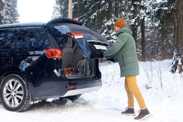 Full shot man closing trunk