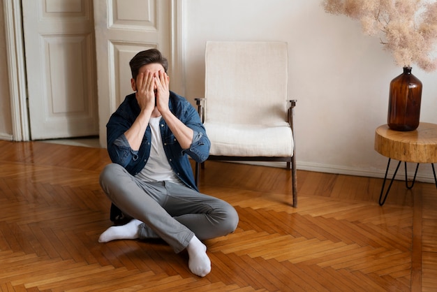 Foto gratuita uomo a tutto campo che si copre il viso