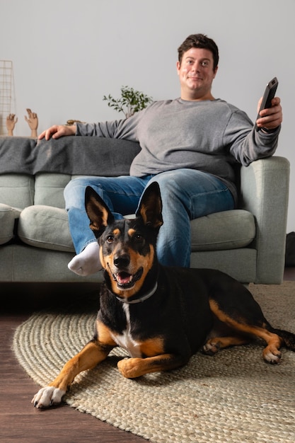 Полный снимок человека и собаки в помещении