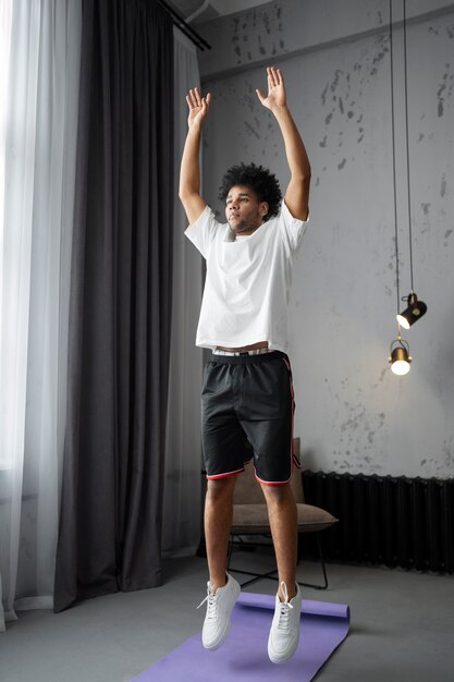 Full shot man doing burpees with mat