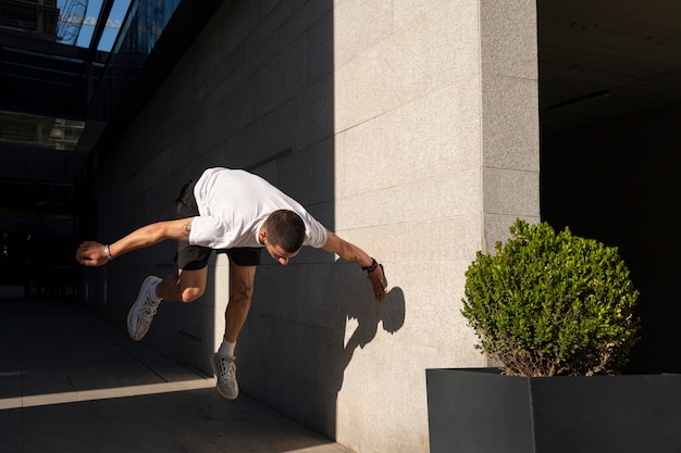 Foto gratuita uomo a figura intera che fa addestramento al parkour