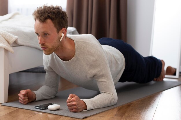 Full shot man doing plank