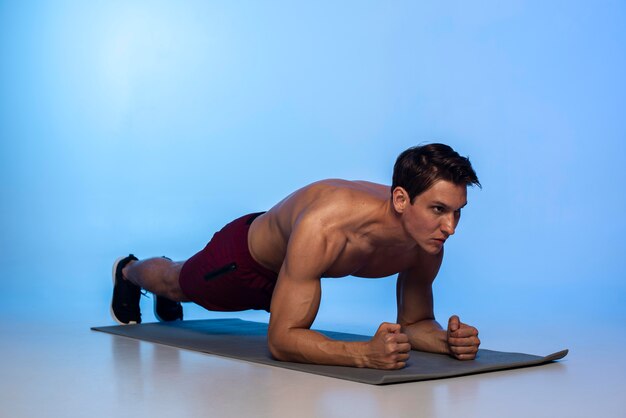 Full shot man doing plank