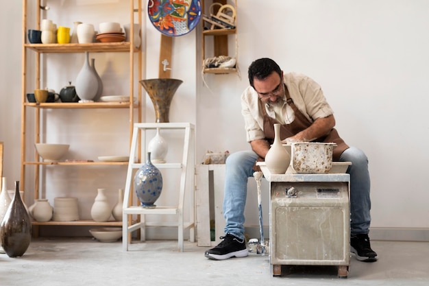 Free photo full shot man doing pottery