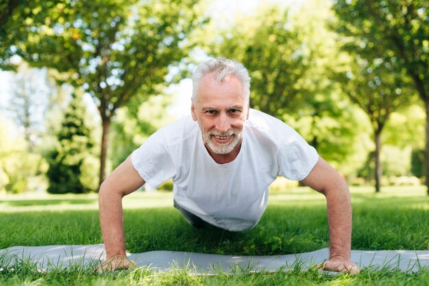 Full shot man doing push-ups outdoors