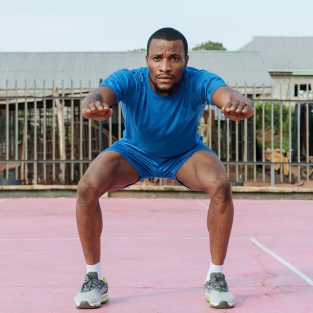 Full shot man doing squats