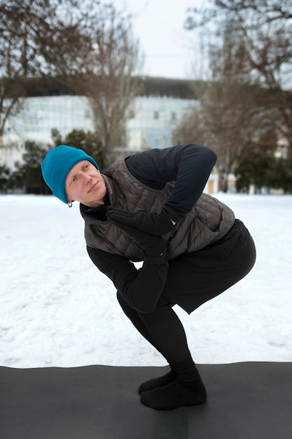 Free photo full shot man doing yoga in cold weather