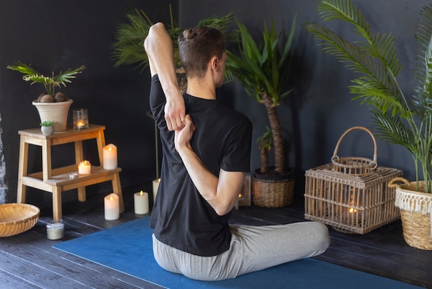 Free photo full shot man doing yoga indoors